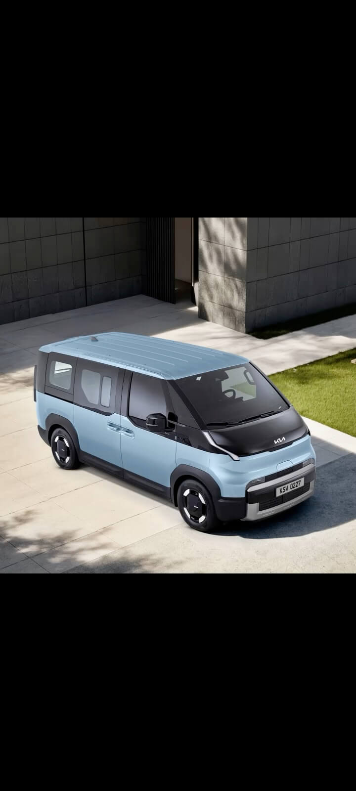 Dreiviertel-Ansicht von oben auf den Kia PV5 Passenger mit dachmontierter Gepäckbox.